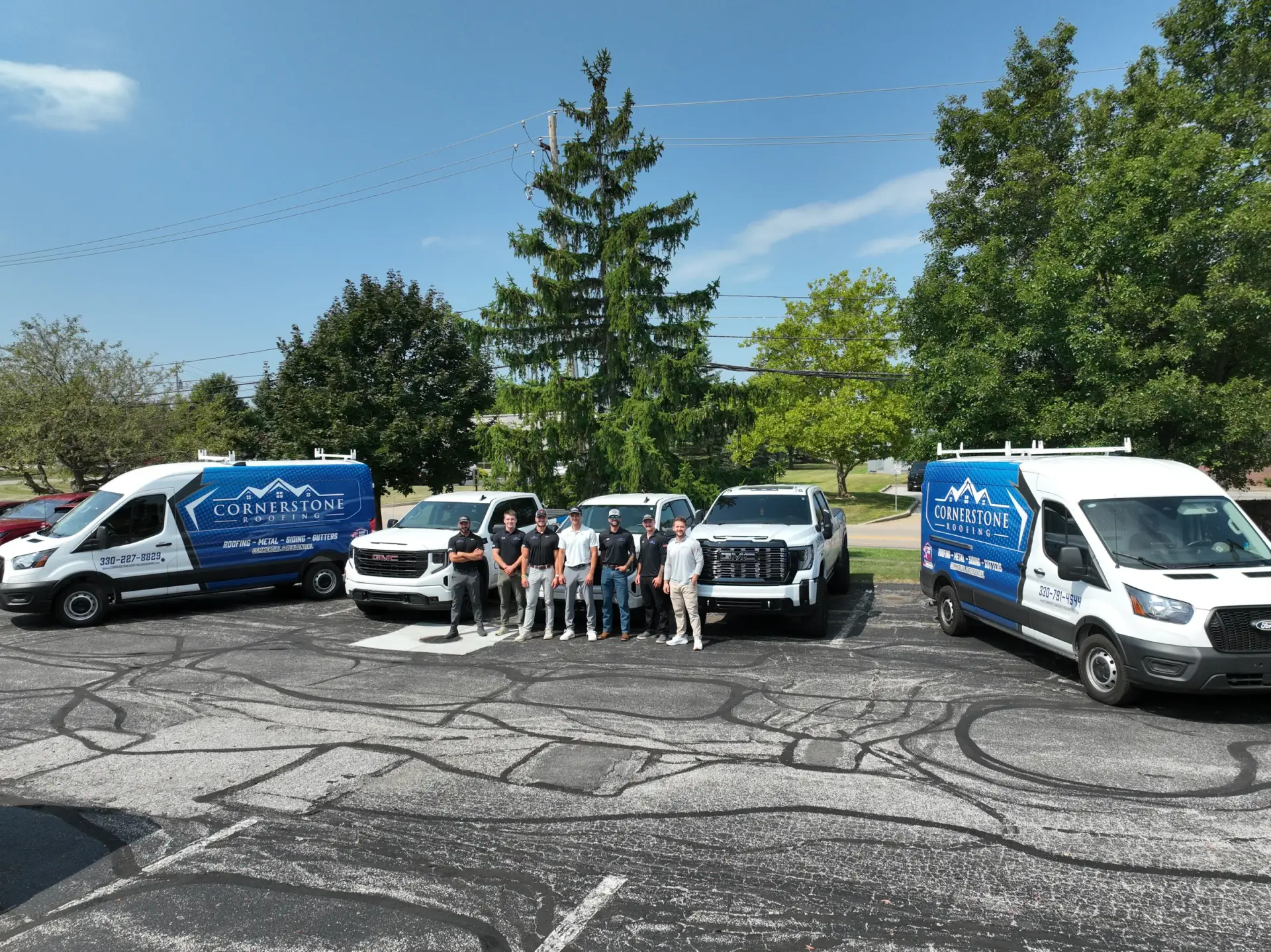 The Cornerstone Roofing and Siding crew with company vehicles at the Wooster, Ohio office
