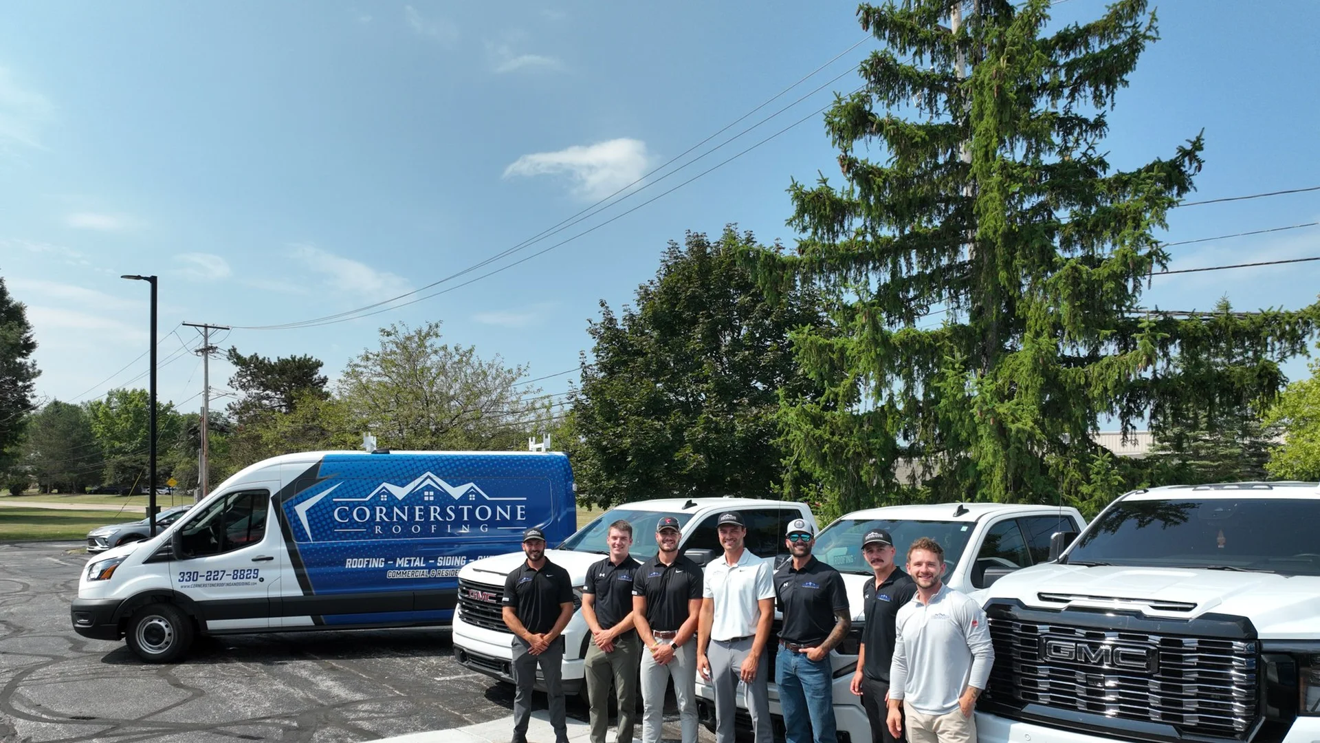 The Cornerstone Roofing and Siding team with company vehicles at the Wooster, Ohio office