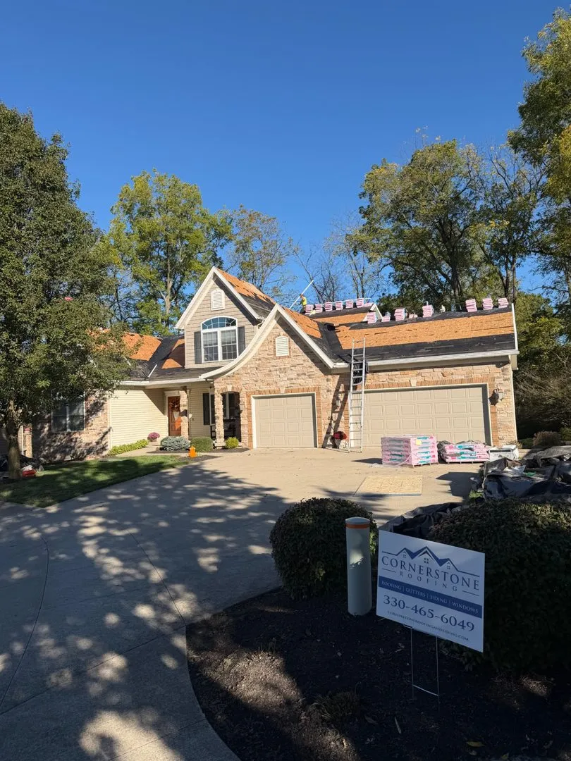 Stone home with Cornerstone yard sign after install